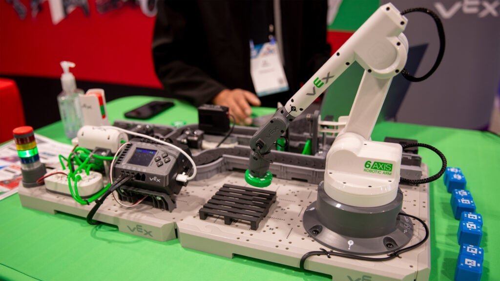 The VEX CTE Workcell's 6-Axis Arm uses an electromagnet to lift a chip.