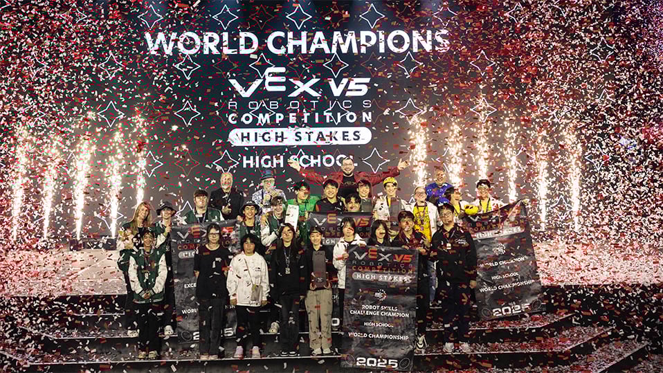 The World Champions for VEX V5 Robotics Competition High School display their banners and smile while confetti rains down.
