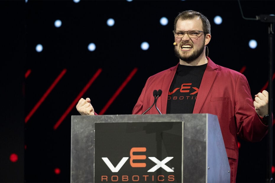 Emcee of the VEX Robotics World Championship, Tyler McCrary, cheers behind the podium.