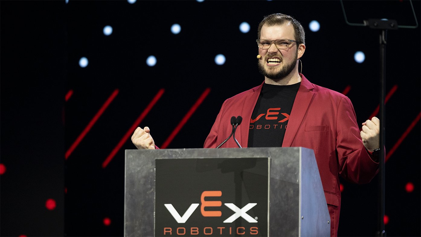 Emcee of the VEX Robotics World Championship, Tyler McCrary, cheers behind the podium.