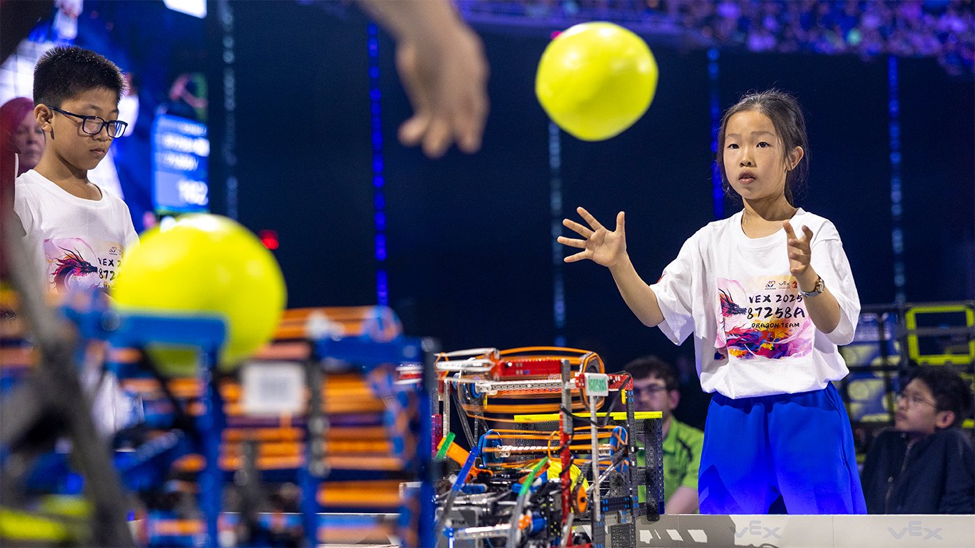 One teammate passes a ball to another while playing VIQRC Rapid Relay.