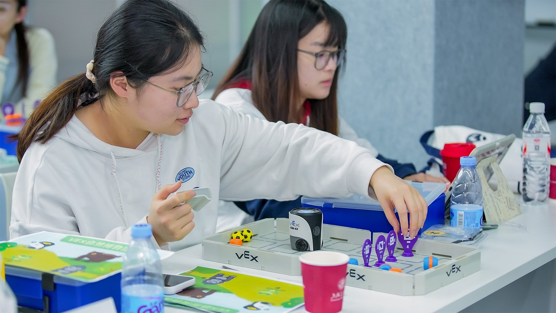 A woman moves an AprilTag sign while using VEX AIM.