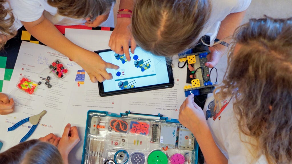 A birds' eye view photo of group of students working together on building a VEX GO robot. 