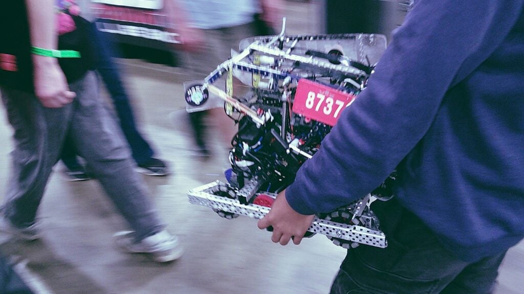 An image by Team 8737A Rampage of a team member walking holding their robot.
