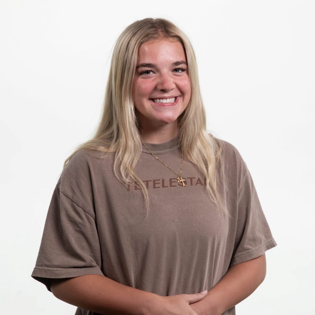 Intern Addie sits in a black chair in front of a white background.