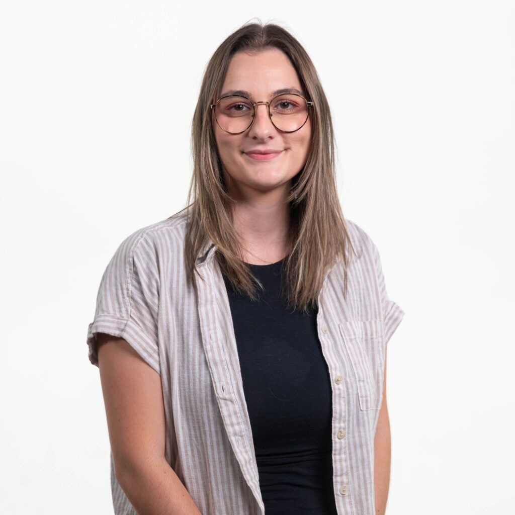 Intern Niah sits in a black chair in front of a white background.